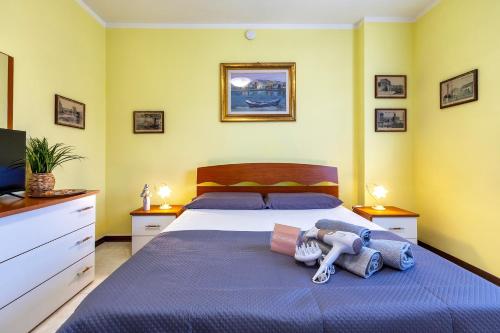 a bedroom with a bed with blue sheets and a television at Cuncordu Affittacamere- Sassari in Sassari
