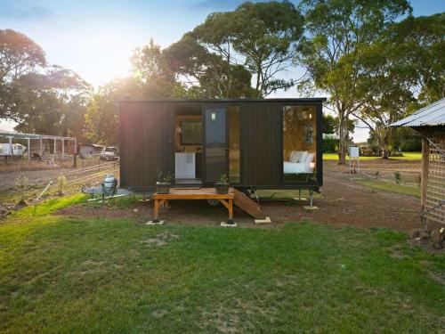 a tiny house sitting on top of a yard at Lara Grove Cottage 2 by Tiny Away in Purdeet