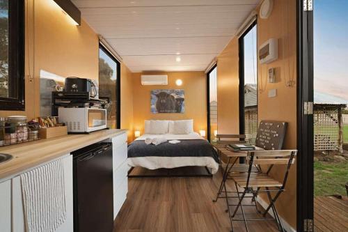 a bedroom with a bed in a tiny house at Lara Grove Cottage 2 by Tiny Away in Purdeet