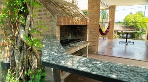 a stone fireplace in a patio with a bench at El descanso - Costa Azul in Villa Carlos Paz