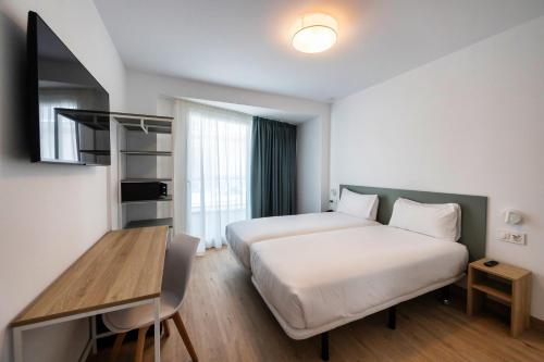 a hotel room with a bed and a desk at Hotel Calella by Beatriz Hoteles in Calella