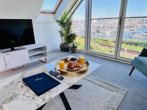 a living room with a table with a plate of food on it at Island Point Horizon View in Lymington