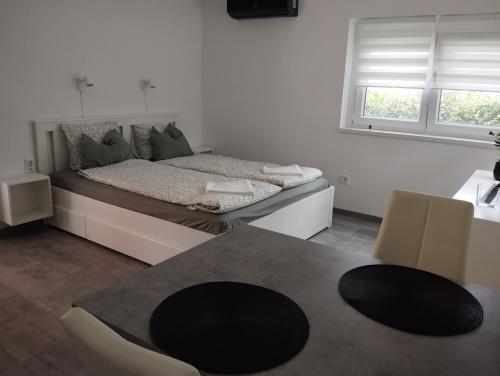 a bedroom with a bed and a table and chairs at RELAX INN Harkány in Harkány