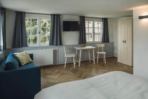 ein Schlafzimmer mit einem Bett, einem Tisch und Stühlen in der Unterkunft Krone Hard in Hard