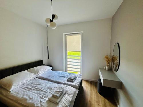 a bedroom with a bed and a mirror and a window at Słoneczny Taras in Kęty