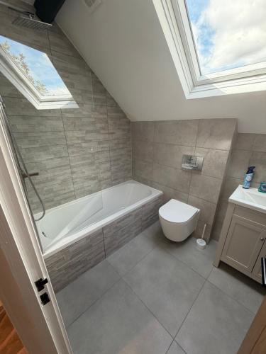 a bathroom with a bath tub and a toilet at Windsor Flat 90A in Windsor
