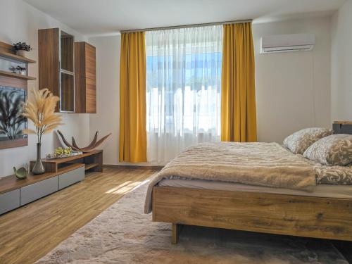 a bedroom with a bed and a large window at Trend Apartman in Bük