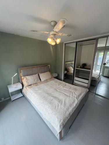 a bedroom with a large bed and a ceiling fan at Spacious King En Suite in St. Albans