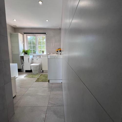 a white bathroom with a sink and a toilet at Spacious King En Suite in St. Albans