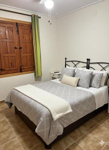 a bedroom with a large bed and a wooden cabinet at Mirador de los Tejados in Alcalá del Júcar