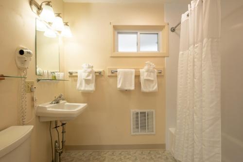 a white bathroom with a sink and a mirror at Wonder View Inn - Bar Harbor Collection in Bar Harbor