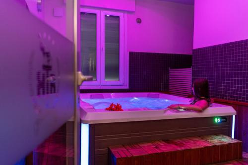 a girl sitting in a tub in a pink room at Hotel Terme Roma in Abano Terme