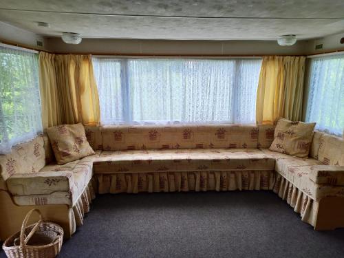 a large couch in a living room with windows at Medumi Lake in Medumi
