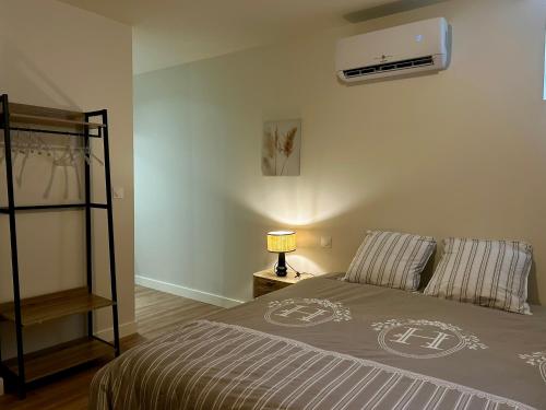 a bedroom with a bed and a fan on the wall at L'Apparth, maison partagée 7 chambres in Parthenay