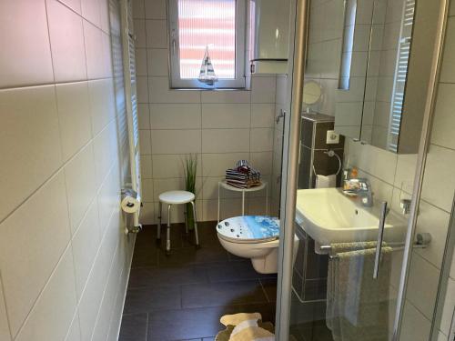 a small bathroom with a toilet and a sink at Kiek mol wedder in in Borkum