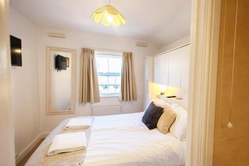 a bedroom with a large white bed with a window at Harbour Penthouse Whitby in Whitby