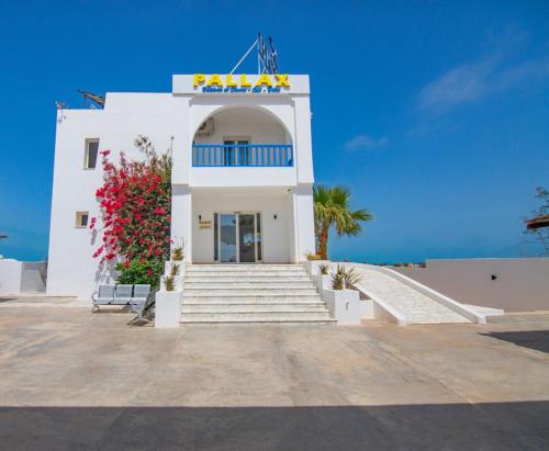 a white building with a sign on it at Pallax hotel in Zarzis