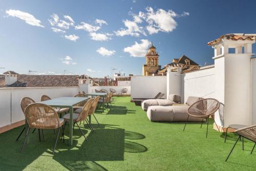 a rooftop patio with green grass and tables and chairs at Cordoba Calle Pozanco in Córdoba