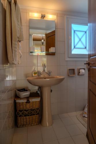 a bathroom with a sink and a mirror at Sofia's Sea View House in Ágios Dimítrios
