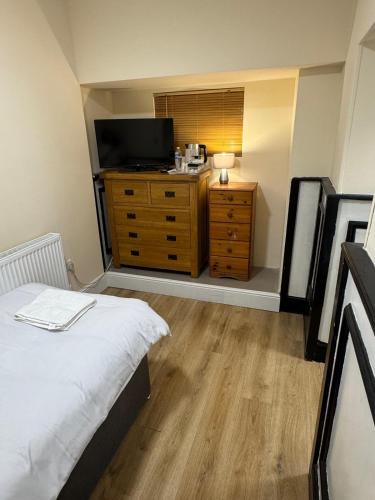 a bedroom with a bed and a tv on a dresser at The Dublin Packet- Single Room 7 in Holyhead