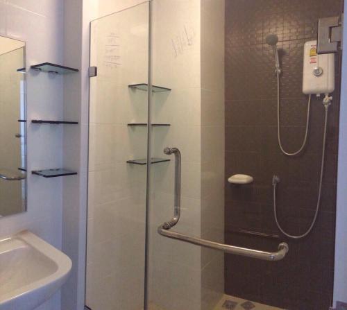 a shower with a glass door and a sink at The Trust Huahin By Sopida in Hua Hin