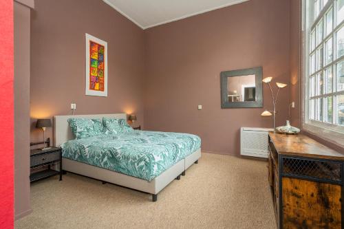 a bedroom with a bed and a dresser and a mirror at Zwaluwenburg 8 in 't Harde