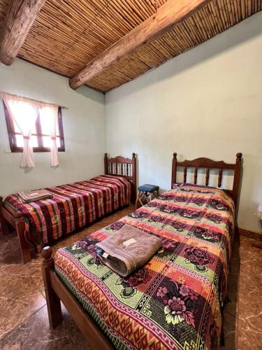 a bedroom with two beds in a room at Kantuta Hospedaje in Tilcara