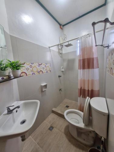 a bathroom with a toilet and a sink at Aquatico Royalle Private Resort in Calamba