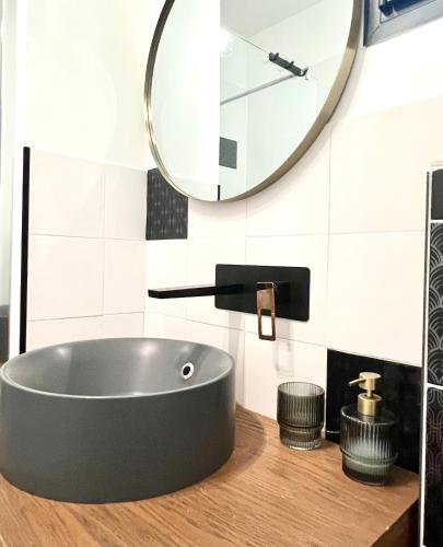 a bathroom with a black sink and a mirror at Sous le figuier in Marseille