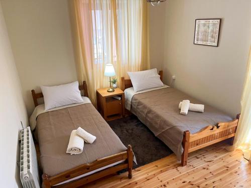 two beds in a small room with towels on them at La Dimora di Basilica in Ágios Matthaíos