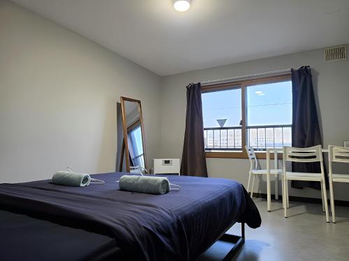 a bedroom with a bed and a large window at Snow Nest Lodge in Sapporo