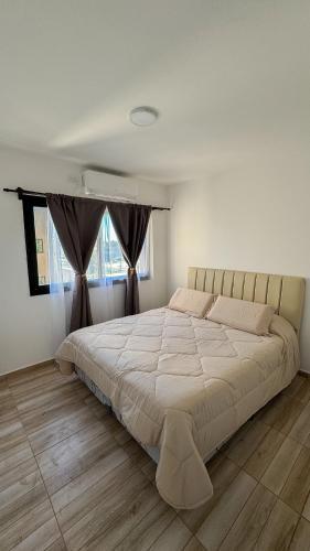 a bedroom with a large bed with a large window at Aires de Laguna in Chascomús