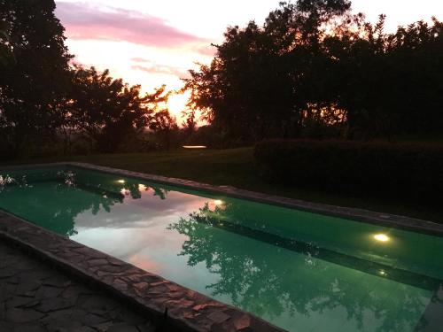 a swimming pool with a sunset in the background at Modern Room with beautiful pool in Bagac