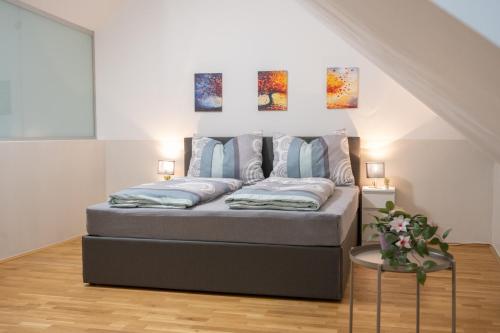 a bed in a room with paintings on the wall at Paky Appartements 00317 in Bruck an der Leitha