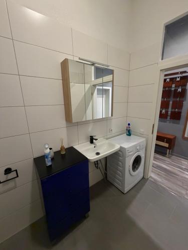 a bathroom with a sink and a washing machine at Smartstay Porta in Porta Westfalica