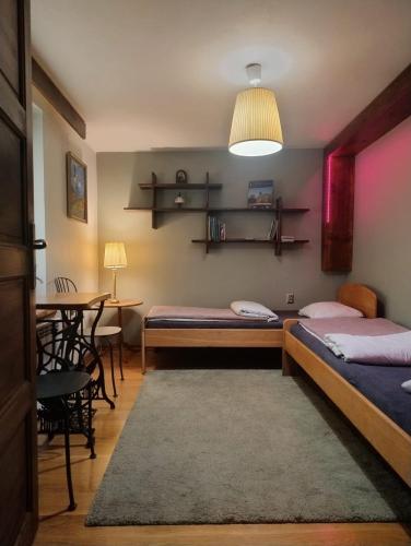 a room with two beds and a table with a dining room at Chata za Wsią u Kowalików in Skała