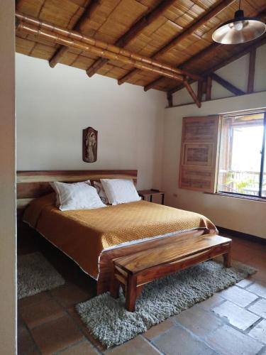 a bedroom with a large bed with a wooden headboard at La Casona Del Retiro in Medellín