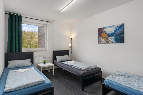 a room with two beds and a window at MK Apartment Delmenhorst nähe Bremen 21 in Delmenhorst