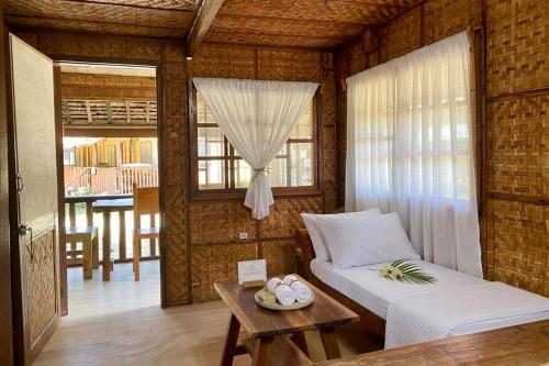 a bedroom with a bed and a table and a window at D Mountain Beach Resort - Beachfront in Puerto Galera