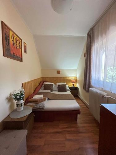 a hotel room with two beds and a window at Alfa Apartman in Harkány