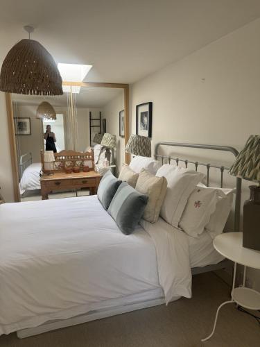 a bedroom with a large bed with white sheets and pillows at The Old Barn in Farthinghoe