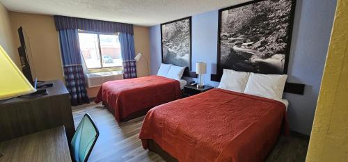 a hotel room with two beds and a television at Gardner Inn in Gardner