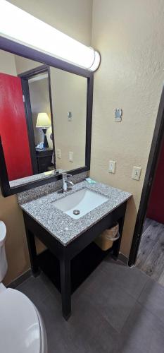 a bathroom with a sink and a mirror at Gardner Inn in Gardner