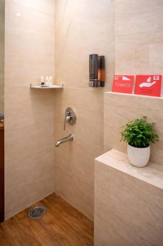 a bathroom with a shower with a plant in it at Goyal Hotelirs - Hotel The Agra Grande, Agra in Agra