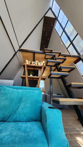 a living room with a blue couch in a loft at Cabaña AlpinA Ixmiquilpan in Ixmiquilpan