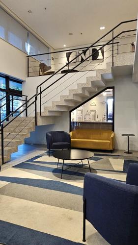 a lobby with stairs and a couch and a table at Transamerica Executive Bela Cintra (Paulista) in São Paulo