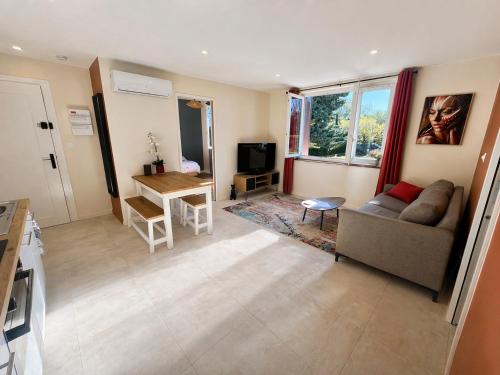 a living room with a couch and a table at Appartement proche Eurexpo Aéroport Genas Centre in Genas