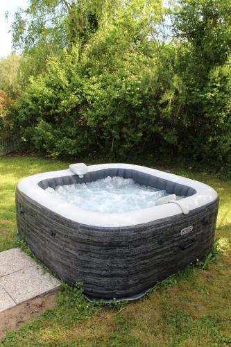a large bath tub sitting in the grass at Le Clos des Soulacaises in Soulac-sur-Mer