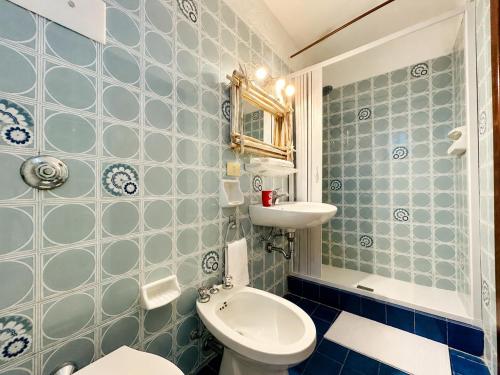 a blue tiled bathroom with a toilet and a sink at Baja Sardinia CB 1 with Pool 100m from the Beach in Baja Sardinia