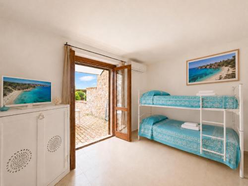 a bedroom with a bunk bed and an open door at Baja Sardinia CB 1 with Pool 100m from the Beach in Baja Sardinia